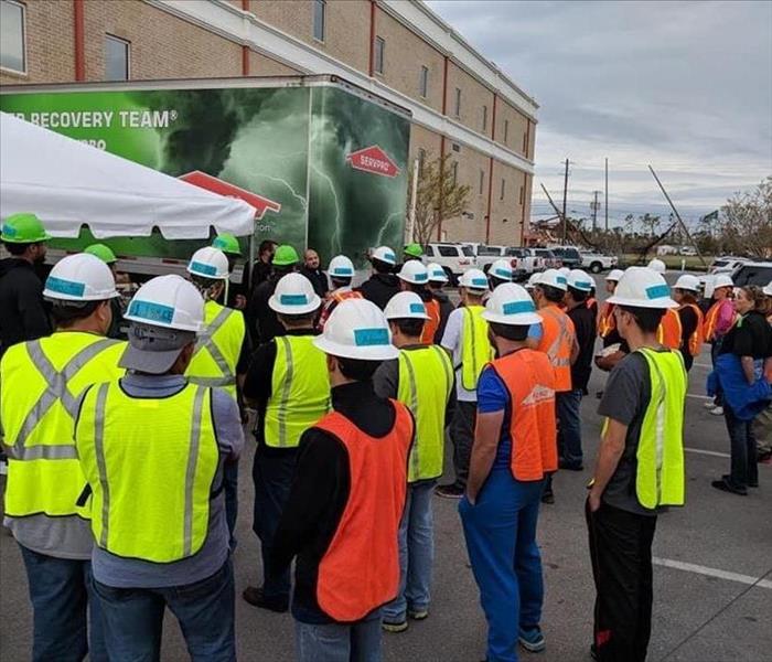 Group of SERVPRO employees attending a safety meeting outside of a commercial jobsite